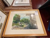 Framed watercolour painting showing floral foliage and waterscape with anchored sailboats, signed Hertzman.