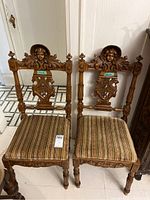 Front view of both chairs showing carved details and upholstery