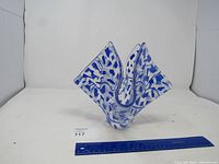 Front angled view of the blue and clear glass vase showcasing its wavy open top and mosaic pattern.