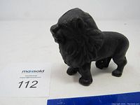 Side view of the black metal lion bank showing its full form and standing posture.