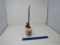 Full view of Mobilgas oiler with pump and spout next to ruler for size reference.