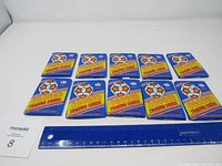 Ten sealed packs of 1990 Soccer Trading Cards laid out on a white surface with a ruler for scale.