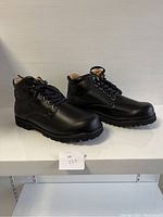 Side view of brand new black leather ladies shoes showing leather texture, laces, and sole pattern.