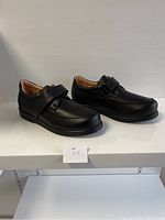 Angle view of the pair of black ladies comfort shoes showing the outer sides and Velcro straps.