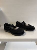 Side angle view of black Orthofeet ladies shoes showing mesh and suede upper, hook and loop strap, and overall shoe shape.