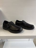 Side view of pair of black leather Orthofeet men’s shoes with hook-and-loop strap, size 8W.