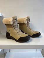Side profile of both boots showing leather upper and shearling cuff