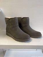 Side view of the pair of UGG boots, showing the suede material and the boot shape.
