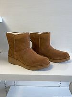 Angled side view of both boots showing suede upper and overall shape