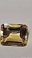Front view of a 2.84 carat golden citrine emerald cut gemstone displaying transparency, facets and brilliance.
