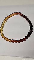 Full view of the Baltic amber necklace showing the full gradient color spectrum from light yellow to dark brown beads.