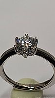 Front view of the sterling silver ring with round brilliant cut moissanite center stone held by multiple prongs.