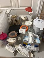 Overview of plastic shelf, metal rack, Brita jug with filters, rice cooker, deli mist, glass jars, and containers on countertop.