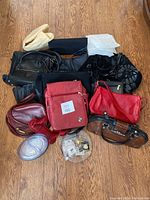 Group shot showing 11 purses of various colors and styles including black, red, burgundy, and brown, along with pins and the jewelry cleaner.