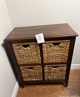 Front view of the 4-drawer storage chest with woven banana leaf basket drawers in a dark espresso brown wood frame.
