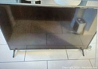 Front view of 49-inch LG TV on V-shaped metal legs