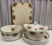 Main group photo showing the Old Country Roses lidded casserole, serving bowl, rectangular rigid placemats, and part of bakeware casserole dish.