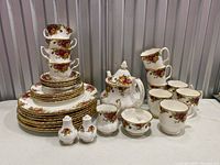 Group shot of entire Royal Albert Old Country Roses set showing teapot, creamer, sugar bowl, salt and pepper shakers, teacups with saucers, mugs, dinner and side plates