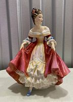 Front view of the Royal Doulton Southern Bell figurine in red, pink, and white dress, about 8 inches tall.