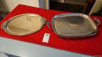 Both trays displayed on a red cloth, showing size and shape differences