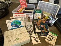 Photo showing the collection arranged with a decorative box of cards, books on anatomy, birds, history, music, and aviation topics.