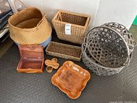 Overview of all baskets, boxes, and wooden trays seen together on a floor