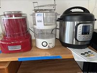Photo showing the three appliances side by side on a wooden surface: Cuisinart ice cream maker, Oster food steamer, and Instant Pot.