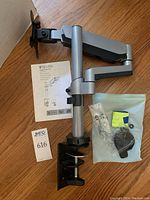 V7 DM1TA monitor desk mount arm with clamp, instruction manual, and hardware pack.