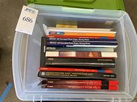 Photo showing large plastic storage box containing various photo paper boxes and packages.