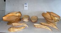 Photo showing the full set arranged: large shell bowl, 6 small bowls, serving spoon and fork, and 6 shell platters