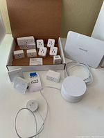 Box with Wemo smart plugs, Powerui smart Wi-Fi wall sockets, Google Wi-Fi mesh router, Netgear base station, and TP Link Ethernet adapters
