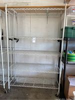 Front view of white five-shelf metal wire shelving unit on casters
