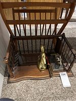 Wooden magazine rack and wooden desktop paper holder placed on carpeted floor, showing vertical slats and turned wood details