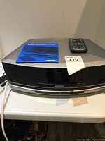 Front view of entire unit with remote and manual on top