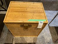 Front view of bamboo look chest showing brass lock and textured bamboo design