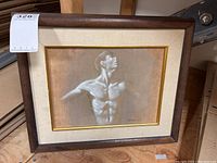 Framed artwork showing male torso study, dark wood outer frame, linen mat and gold inner liner