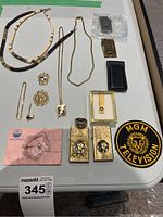 Overview of two lighters, assorted clips, necklaces, pins, ring, patch and pin