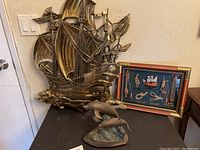 Dolphin statue in front of ship wall decor and nautical knot art on a black surface