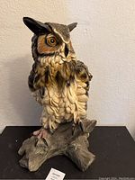Front view of the owl statue showing detailed feathers, face, and base.