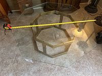 View from above showing the octagonal glass top and brass base with a tape measure indicating approximately 46 inches width.