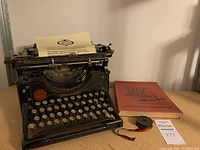 Front view of Underwood typewriter with paper and 20th Century Typing book and spool beside it