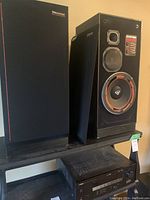 Pair of Cerwin-Vega 250 SE speakers and Yamaha RX-V450 AV receiver. One speaker front grille removed showing woofer damage.