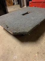 Top and side view of furniture dolly showing grey carpeted surface with wear and frayed edges.