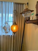 Photo showing all three vintage hanging lamps including the orange glass globe pendant, brass chandelier with crystals, and vintage wall lantern.
