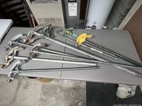 Photo showing six pipe benders laid out on a table with visible handles and curved bending forms.