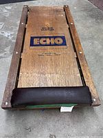 Top view of the wooden car dolly showing Echo branding and padded end.