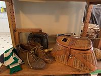 Overview of vintage sports equipment including fishing creel, leather soccer cleats, a green-white striped sock, and wooden rackets