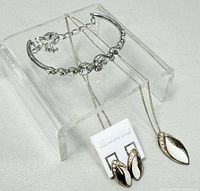 Photo showing the 18-inch 925 silver necklace with a smooth leaf-shaped pendant, matching earrings on 925 silver card, and Swarovski crystal bracelet with pear-shaped crystals.