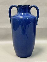 Front view of the blue stoneware urn showing the full body and handles.