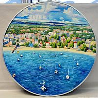 Front view of 32-inch round oil painting showing coastal town, beach, sailboats, buildings and clouds under a blue sky.